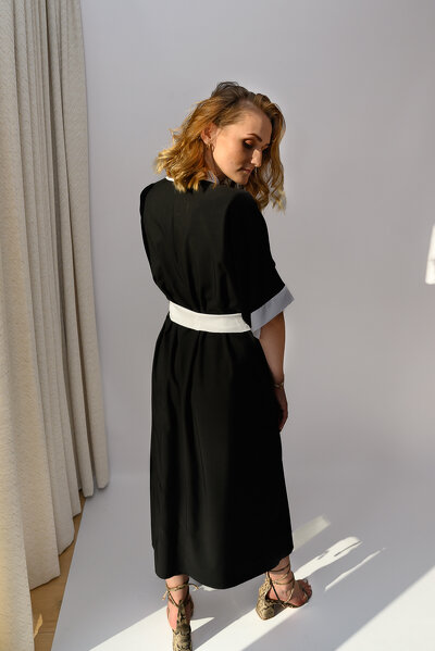 Czarna letnia sukienka o zakładanym fasonie i wiązaniem w pasie