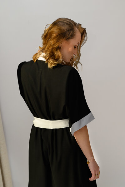 Czarna letnia sukienka o zakładanym fasonie i wiązaniem w pasie