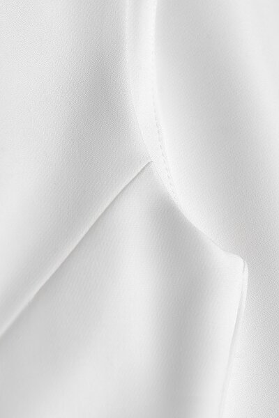 Dopasowana sukienka w kolorze śmietanki z głębokim dekoltem