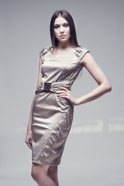 Elegancka beżowa sukienka z ozdobną klamrą